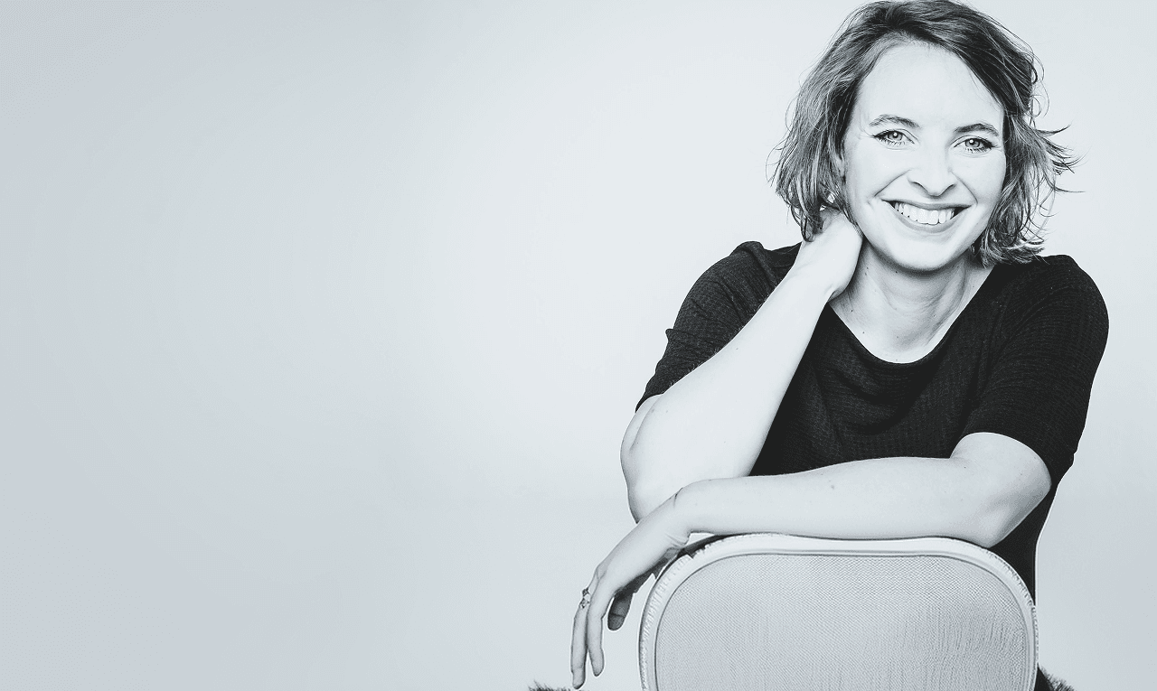Dr. Lena Barth, lächelnd, an eine Stuhllehne gelehnt